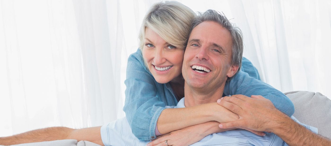 Smiling man and woman on couch