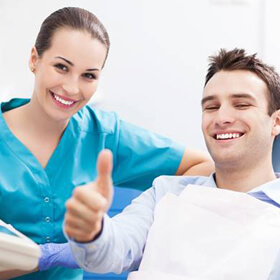 Man in dental chair giving thumbs up