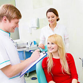 Woman in dental chair talking to dentist