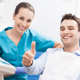 Smiling man in dental chair giving thumbs up