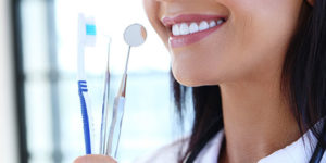 person smiling next to dental items